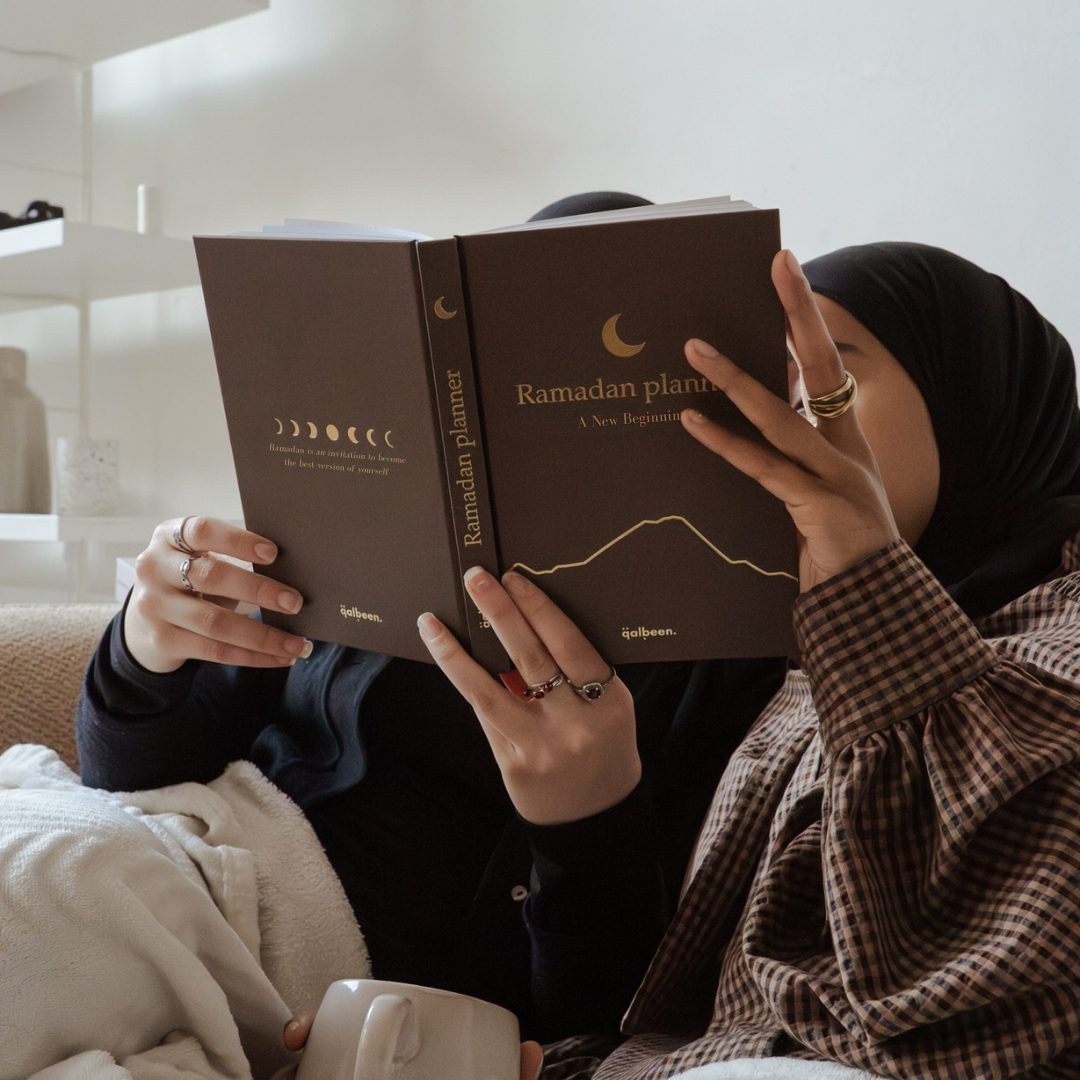 A woman reading her Ramadan Planner at home